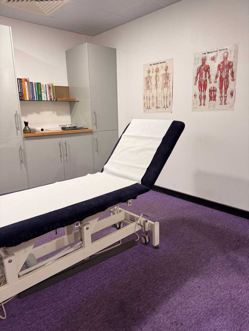 Silkens Sports Massage treatment room with massage couch and anatomy posters